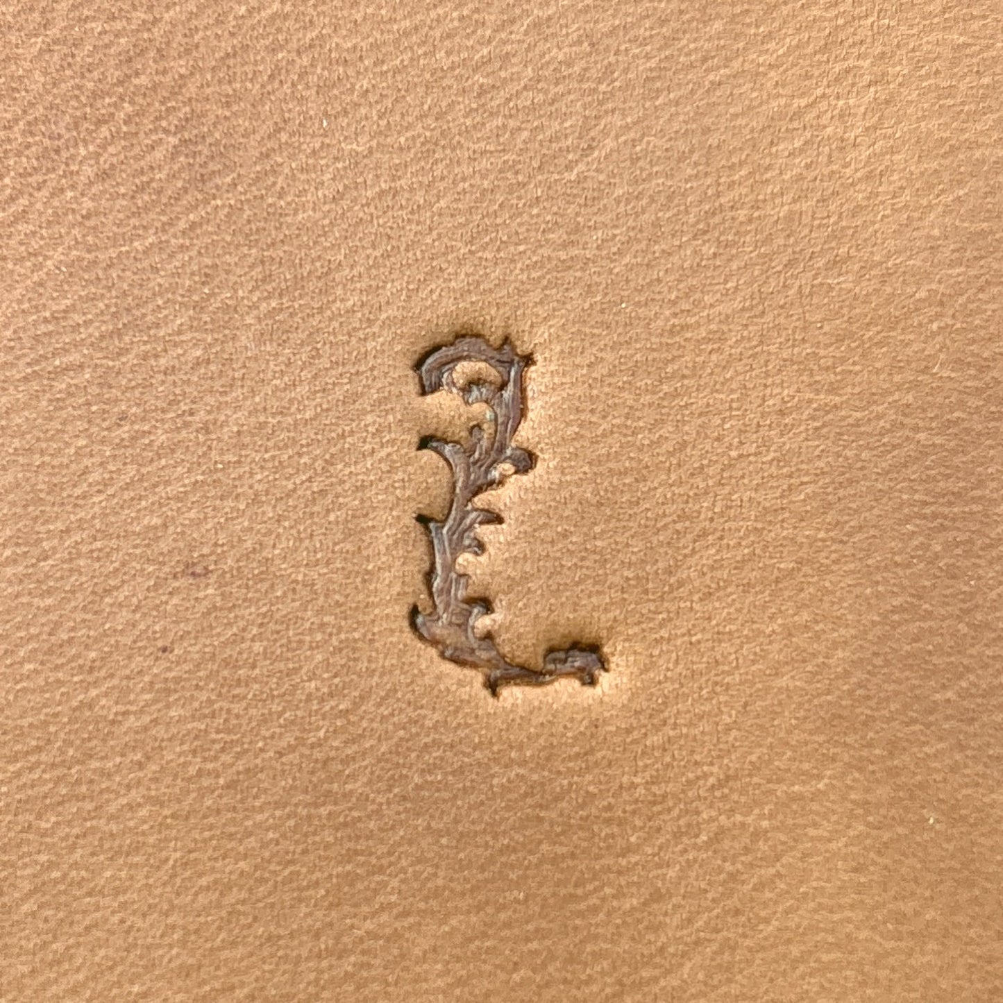 Ornate Initial Flower leather stamp LT711 — single impression on veg-tan leather