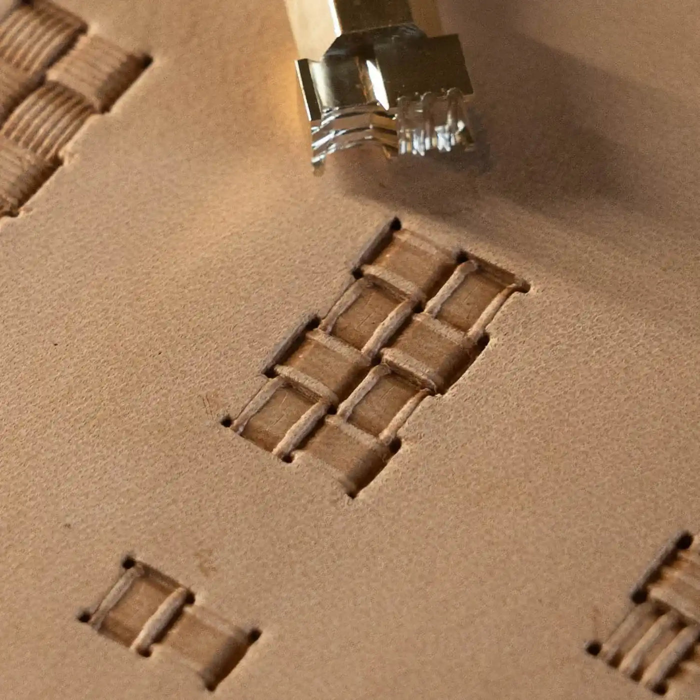 A basketweave pattern struck across tan leather.