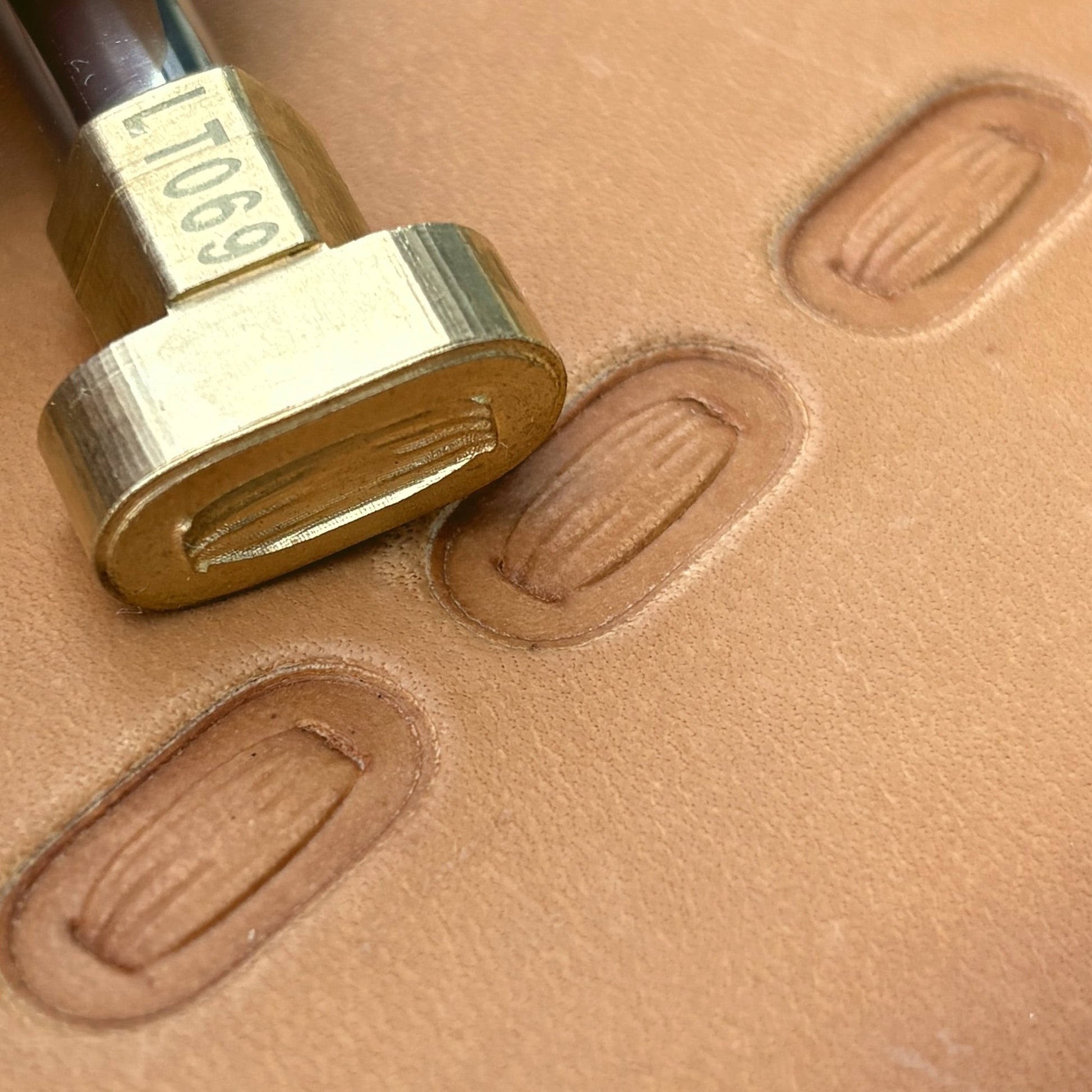Oval Stitches leather stamp LT069 — brass stamping tool with imprint on natural veg-tan leather