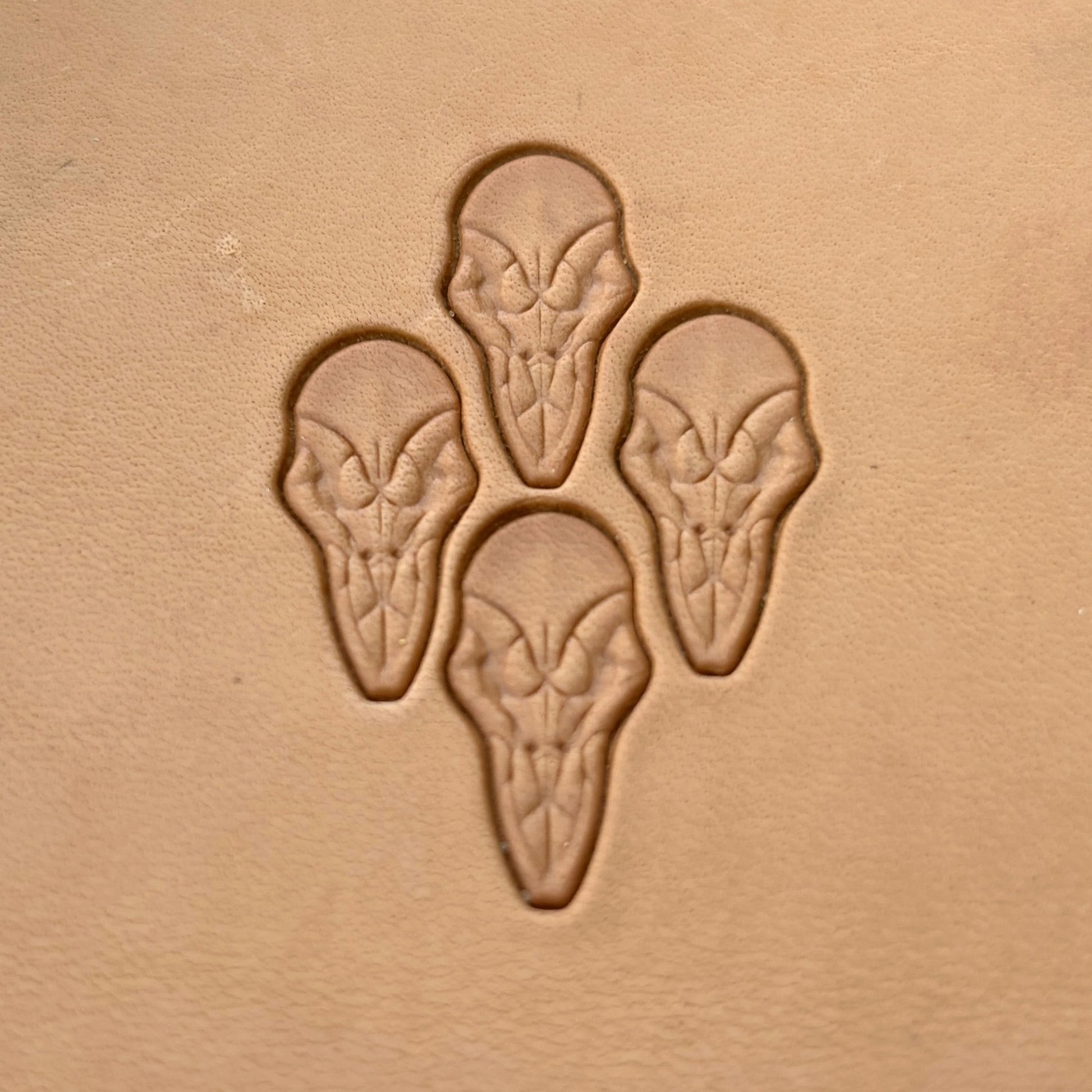 Alien Skull leather stamp LT077 — single impression on veg-tan leather