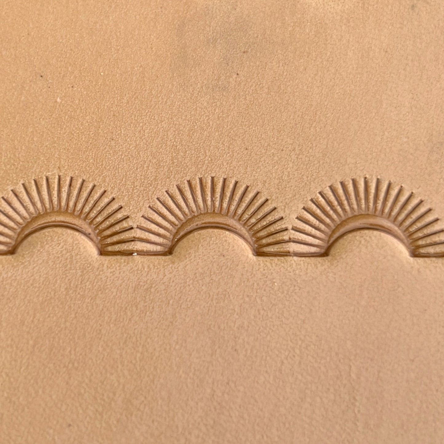 Sunburst Border leather stamp LT124 — single impression on veg-tan leather