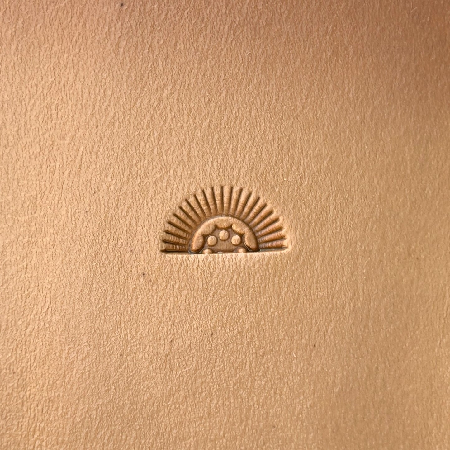 Sunrise leather stamp LT133 — single impression on veg-tan leather
