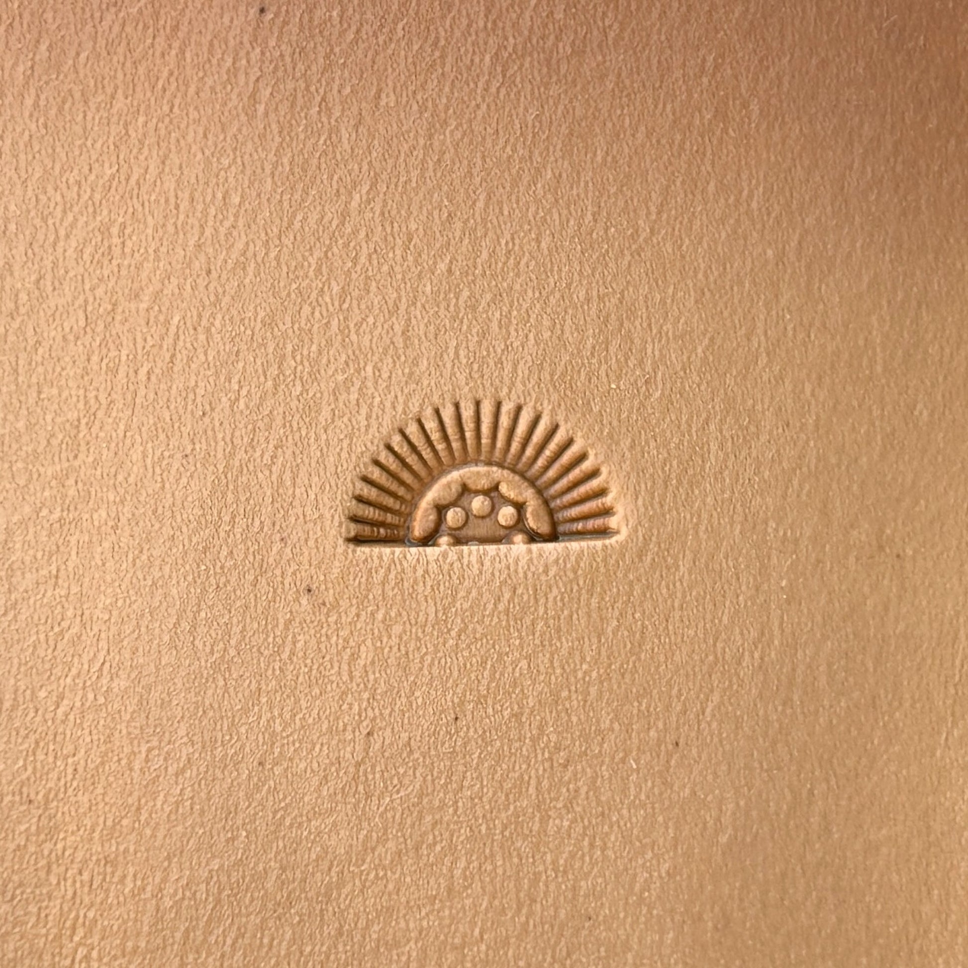 Sunrise leather stamp LT133 — single impression on veg-tan leather