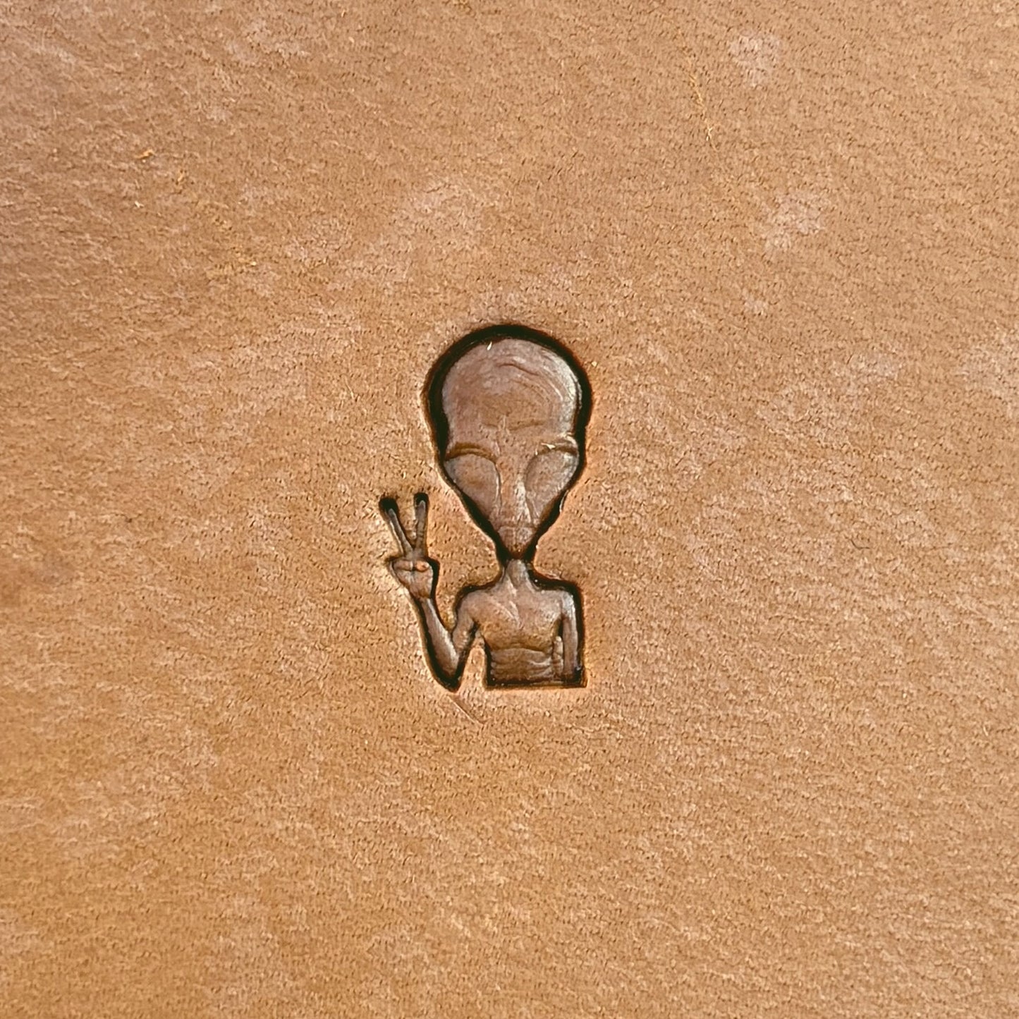 Peace Alien leather stamp LT676 — single impression on veg-tan leather