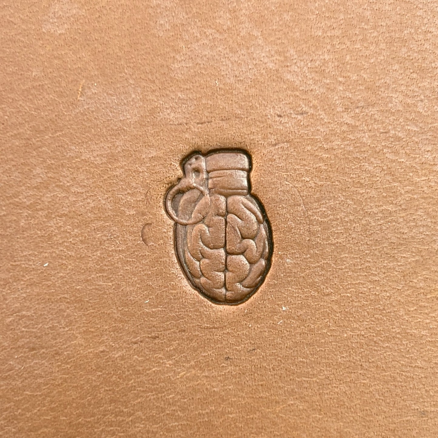 Brain Grenade leather stamp LT722 — single impression on veg-tan leather