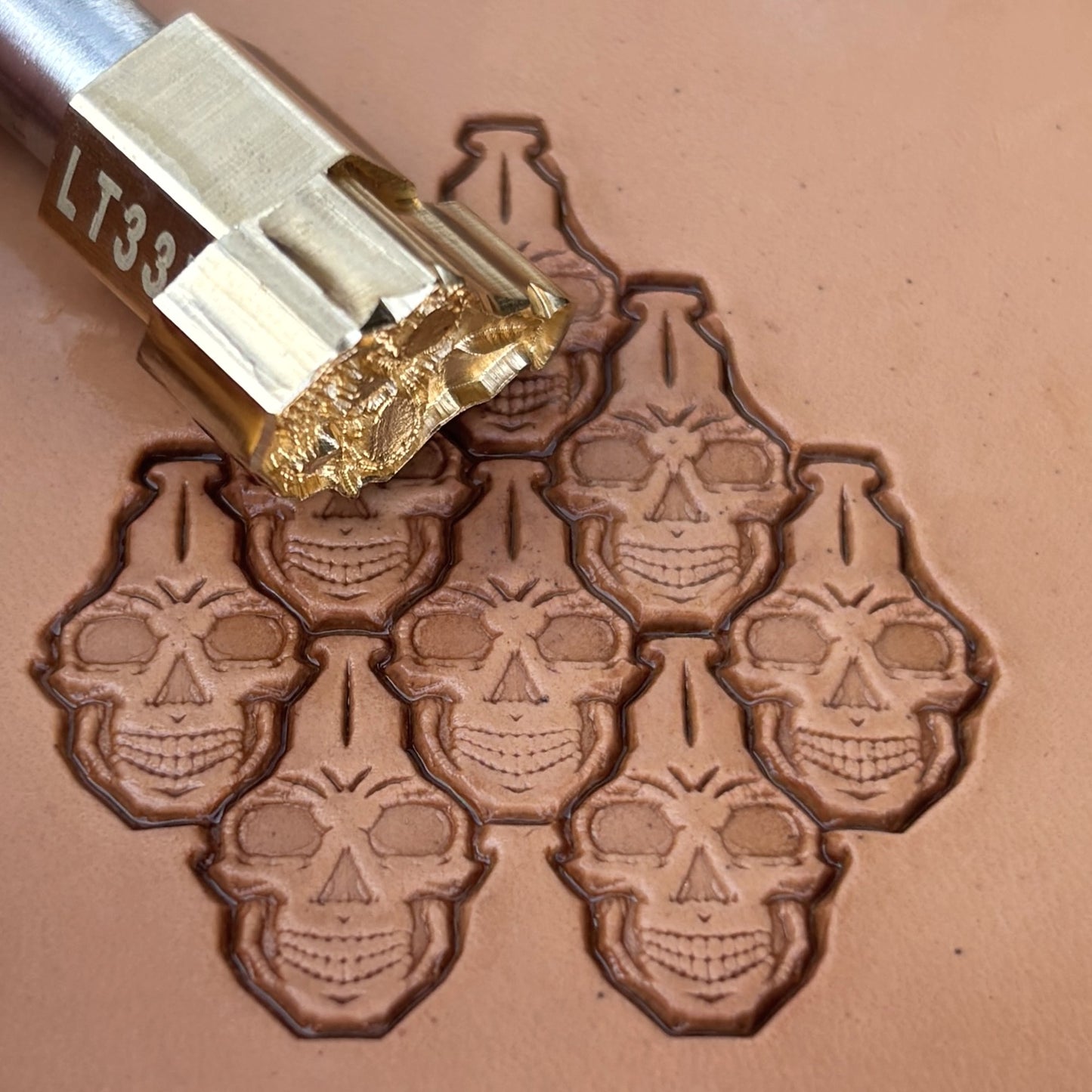 Interlocking Skulls leather stamp LT835 — brass stamping tool with imprint on natural veg-tan leather