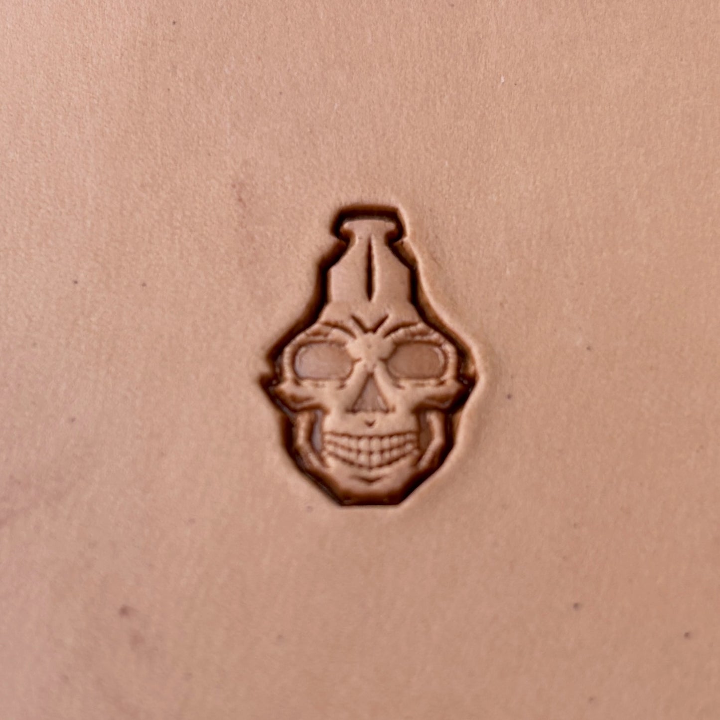 Interlocking Skulls leather stamp LT835 — single impression on veg-tan leather